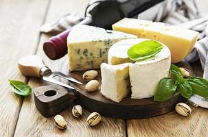 Various types of cheese, grapes, wine and snacks photo