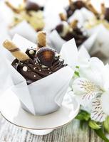 Chocolate cupcakes on white wooden background photo