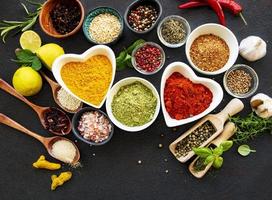 Various spices in bowls on black concrete background