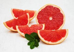 Grapefruit with mint and ice on an old white wooden background photo