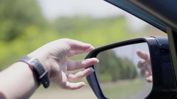 câmera lenta mão mulher turista sair do carro toque vento natural enquanto dirige na estrada secundária com montanha de árvore e luz do sol na manhã viajante relaxante desintoxicação digital na paisagem video