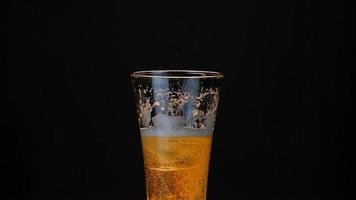 Put ice into the rotating beer glass 360 degrees video
