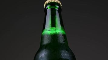 Primer plano la botella de cerveza está hecha de vidrio verde girando 360 grados video