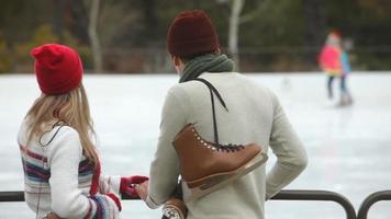 pareja junto a la pista de patinaje sobre hielo video