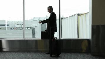 Mature business man at airport waits for airplane video