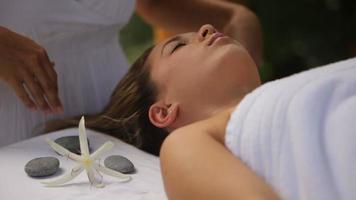 vrouw krijgt massage in outdoor spa, close-up video