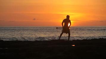 Hawaiian fire knife dancer performs at sunset