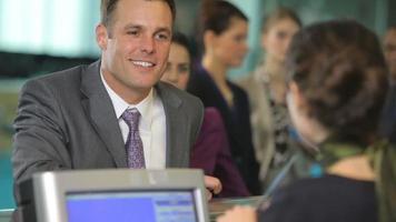 Airport passengers check in at ticket counter video