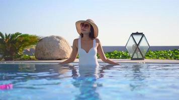 mulher asiática relaxando ao redor de uma piscina ao ar livre video