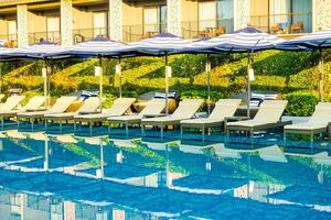 Sombrilla y cama de piscina alrededor de la piscina al aire libre en el hotel resort para viajes vacaciones vacaciones foto