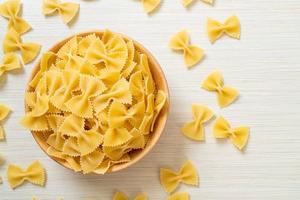 Dry uncooked farfalle pasta in bowl photo