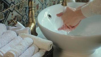 Woman washes her hands and dries them concept of cleanliness video