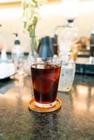 Cold brew coffee or Americano black coffee in a glass with ice cubes at a coffee shop cafe photo