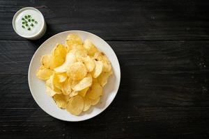 Potato chips with sour cream dipping sauce photo