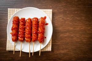 Fried sausage skewer with ketchup on a white plate photo