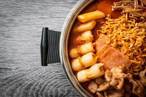 budae jjigae o budaejjigae, estofado del ejército o estofado de base del ejército, con kimchi, spam, salchichas, fideos ramen y más: estilo popular coreano de olla caliente foto