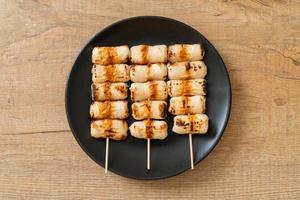 Grilled tube-shaped fish paste cake or tube squid skewer on plate photo