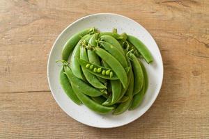 Fresh sweet green peas on a white plate photo