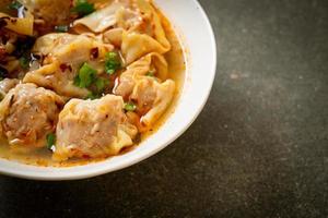 Pork wonton soup or pork dumplings soup with roasted chili - Asian food style photo