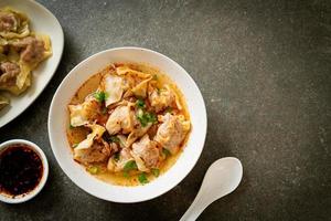 sopa de wonton de cerdo o sopa de albóndigas de cerdo con chile asado - estilo de comida asiática foto