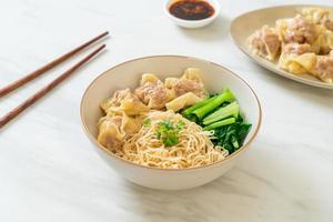 Dried egg noodles with pork wonton or pork dumplings without soup - Asian food style photo