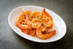 Fried shrimp or prawns with garlic on a white plate - seafood style photo