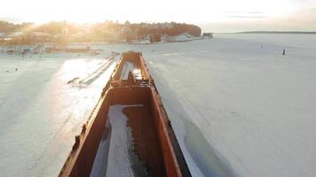 Old ship barge on a frozen river aerial shooting video