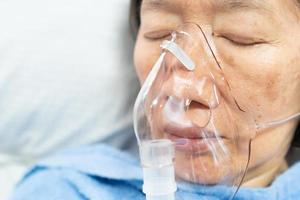 Close up face of senior asian patient having viral pneumonia were treated with oxygen therapy in the hospital photo