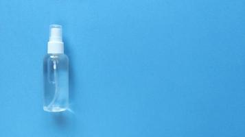 Desinfectante De Manos Botella Transparente Con Tapa Rociadora A La Izquierda Del Fondo Azul Plano Simple Con Espacio De Copia Textura De Papel Pastel Concepto Médico foto