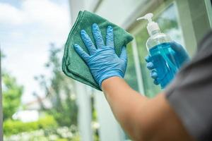 Maid cleaning wipe and wash the glass at widow in home photo