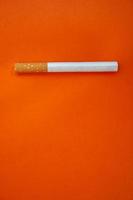 tabaco de cigarrillo en el fondo naranja foto