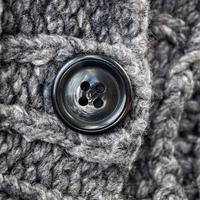 botón negro en la lana gris