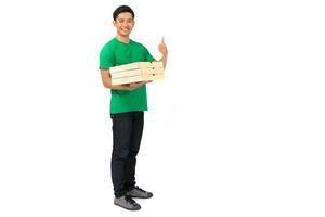 Smiling delivery man employee in blank t shirt uniform standing with credit card giving food order and holding pizza boxes