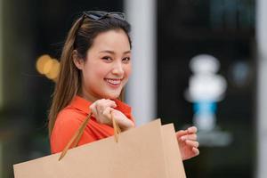 Retrato al aire libre de mujer feliz sosteniendo bolsas de la compra. foto