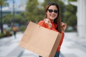 Retrato al aire libre de mujer feliz sosteniendo bolsas de la compra. foto