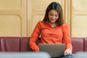 Hermosa joven con laptop sentada en una cafetería. foto