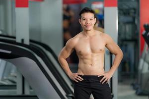 Handsome sporty man posing in gym photo