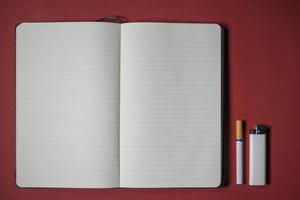 cigarette lighter and notebook writing on a red background photo