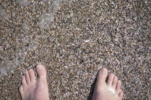 feet on the sand in the sea in summer photo