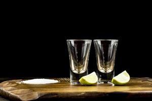 dos vasos de tequila con limón y sal