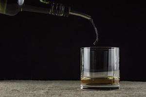 whiskey is poured into a glass photo