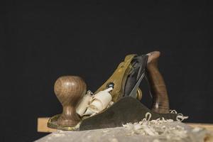 hand plane and shavings on a black background photo