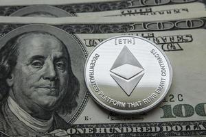 Crypto currency ethereum on the background of the dollars photo