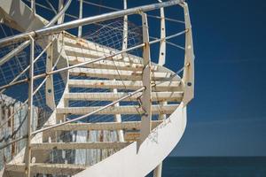 a white spiral staircase by the sea photo