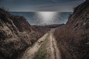 road to the sea between the rocks on a sunny day photo