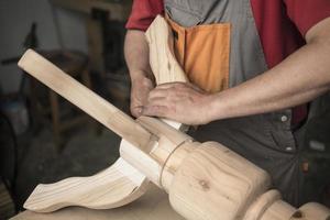 carpenter makes a table with carved legs photo