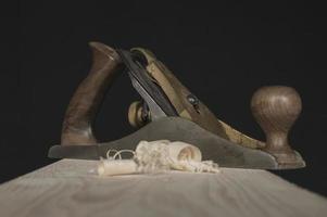 hand plane and shavings on a black background photo