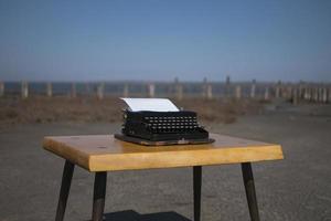 Máquina de escribir sobre la mesa en el estuario al aire libre en el fondo foto