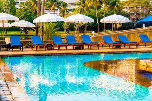 Beautiful umbrella and chair around swimming pool in hotel and resort photo