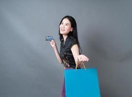 Asian woman wear Chinese traditional dress with shopping bag and credit card